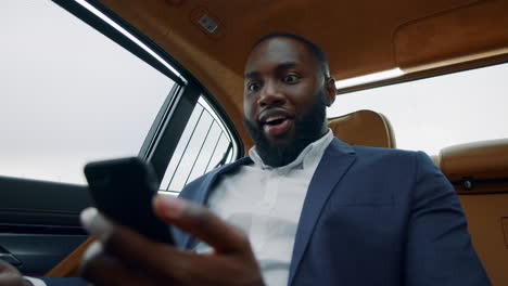 portrait of afro businessman getting good news. african man celebrating victory