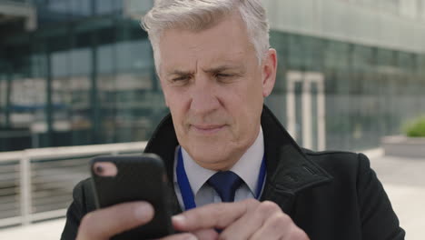 close up portrait of successful businessman browsing messages texting using smartphone networking happy enjoying mobile technology