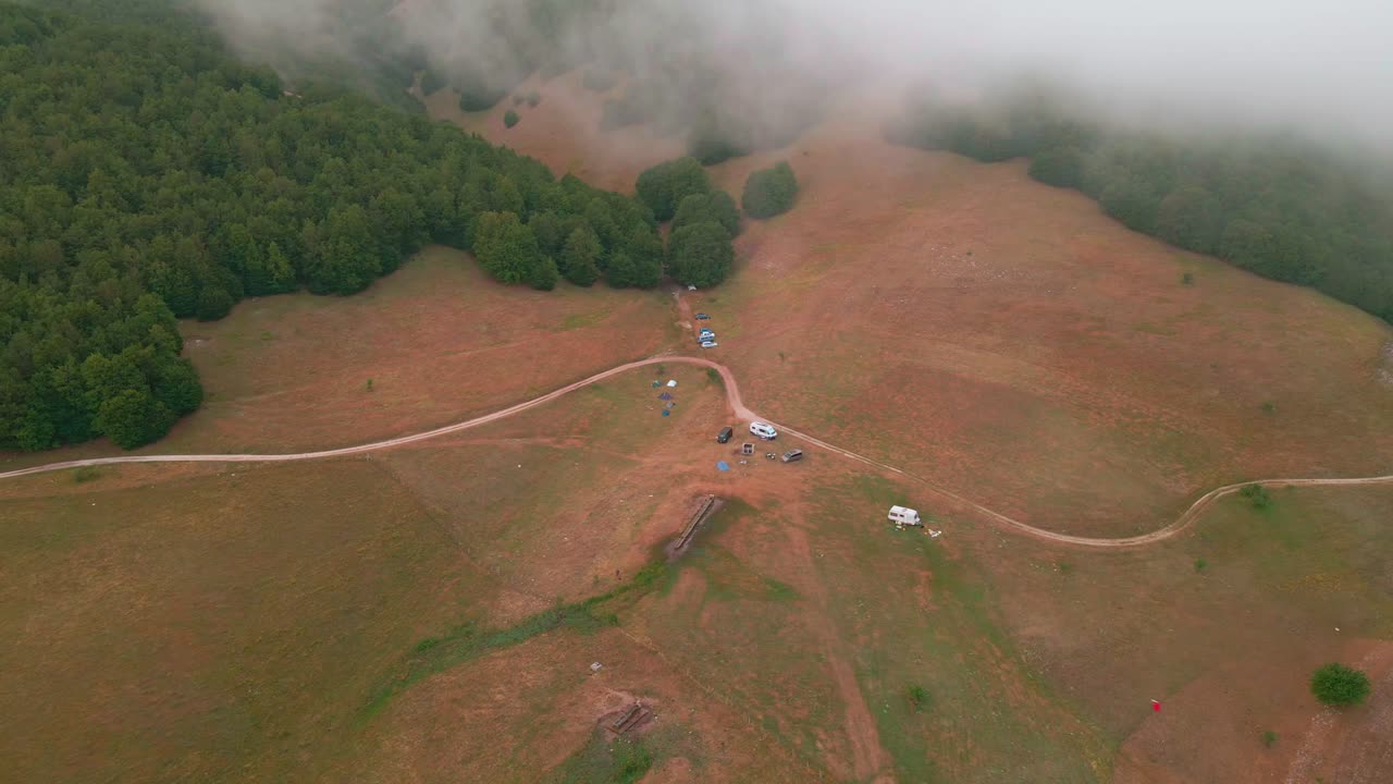 이탈리아 카스텔루치오 근처에서 안개 낀 아침에 캠핑을 즐기는 휴가객들과 함께 평원과 울창한 숲의 아름다운 전망