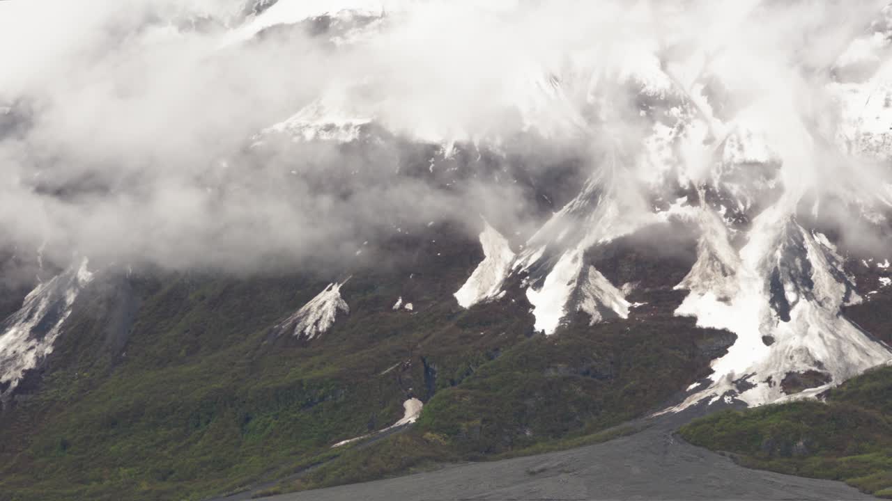 Witness dramatic glacier formations in Alaska as clouds roll over the stunning landscape. Experience the awe of nature's beauty and the power of glacial movement in this captivating location.