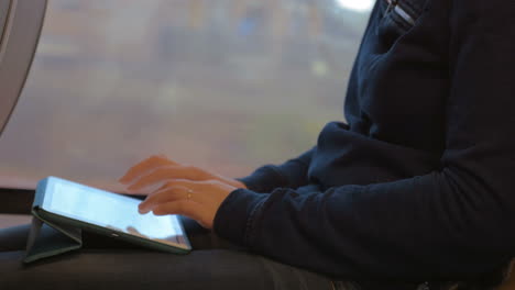 woman writing on tablet pc during the trip