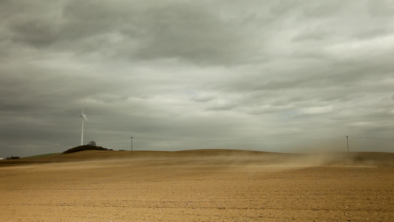 회색 구름이 가득한 하늘 아래의 황폐한 밝은 갈색  ⁇ 에서  ⁇  세  ⁇ 의 풍력 터빈, 황폐하고 외로운 오라를 발산