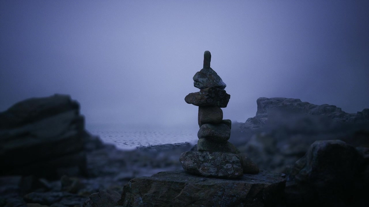 Composizione serena di pietre erose circondate da nebbia e foschia.