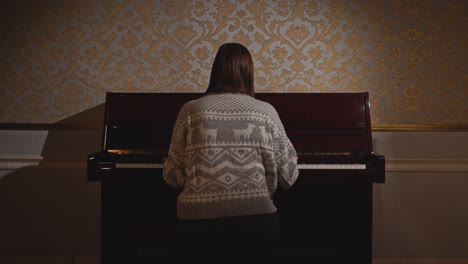 woman playing piano in elegant room