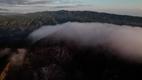 foggy landscape of mount batur in bali, indonesia - aerial drone shot