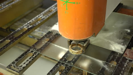 cnc machine drilling holes into glass panel