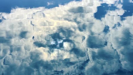 weiße wolken spiegeln sich im wasser des schwimmbades