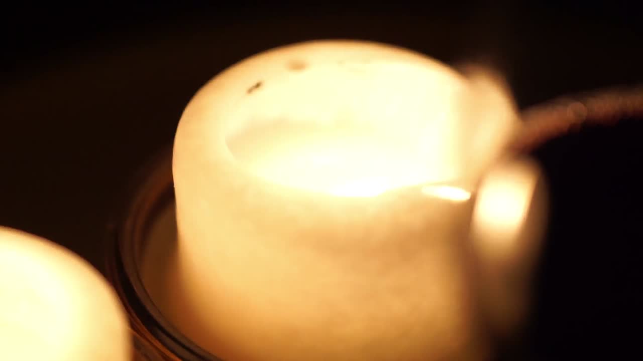 불타는 촛불 두 개 앞에서 적포도주 한 잔