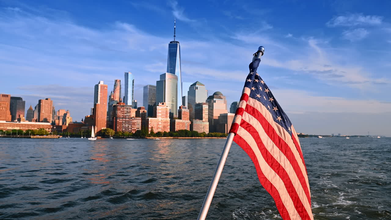 Die amerikanische Flagge auf dem Bootssteg, während es auf dem Fluss fährt. Hochhäuser in der Skyline von New York im Hintergrund
