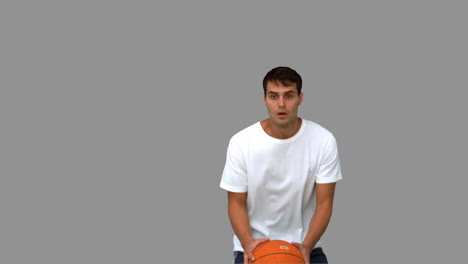hombre atrapando y lanzando una pelota de baloncesto en la pantalla gris