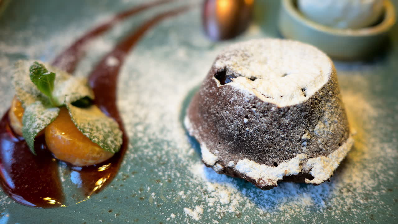 Chocolate lava cake with ice cream and orange decoration in a restaurant