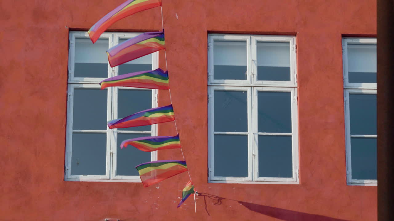 Colorful LGBT Flags Hanging On String And Blown By The Wind In Nyhavn, Copenhagen, Denmark. static
