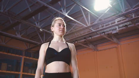 Happy-Blonde-Sportswoman-Jumping-And-Cheering-To-Celebrate-Victory-In-An-Indoor-Sport-Facility