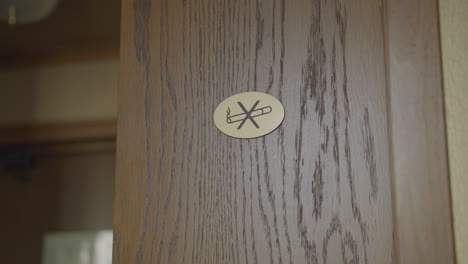 no smoking sign on an interior wooden door