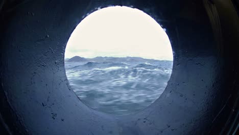 view through a ship's porthole while under way in the galapagos islands national park and marine reserve ecuador