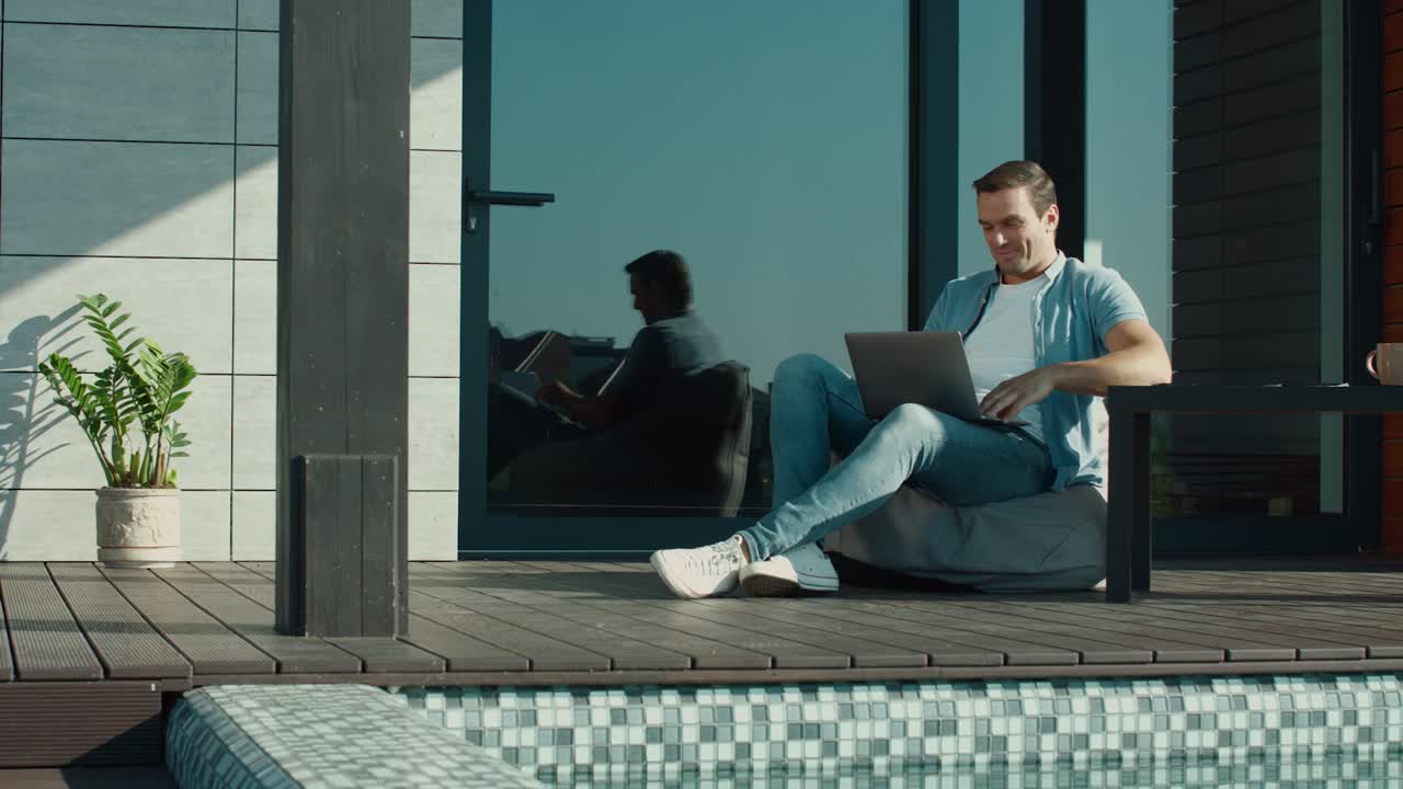 hombre relajado hablando en línea en una computadora portátil afuera. hombre feliz hablando en un cuaderno.