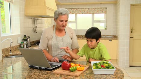 Woman-giving-her-grandson-a-cookery-lesson-