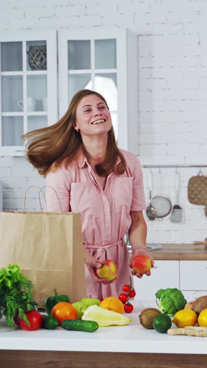 Young woman in the kitchen. Woman having fun in the kitchen while cooking Vertical video