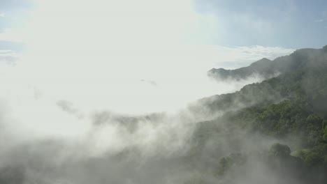 Forward-drone-shot-flying-through-the-clouds-revealing-the-morning-sun-in-the-mountain-ranges-of-Western-Ghats-in-India