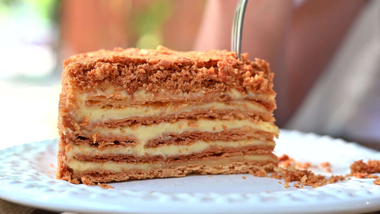 Woman eating a millefeuille cake, close up