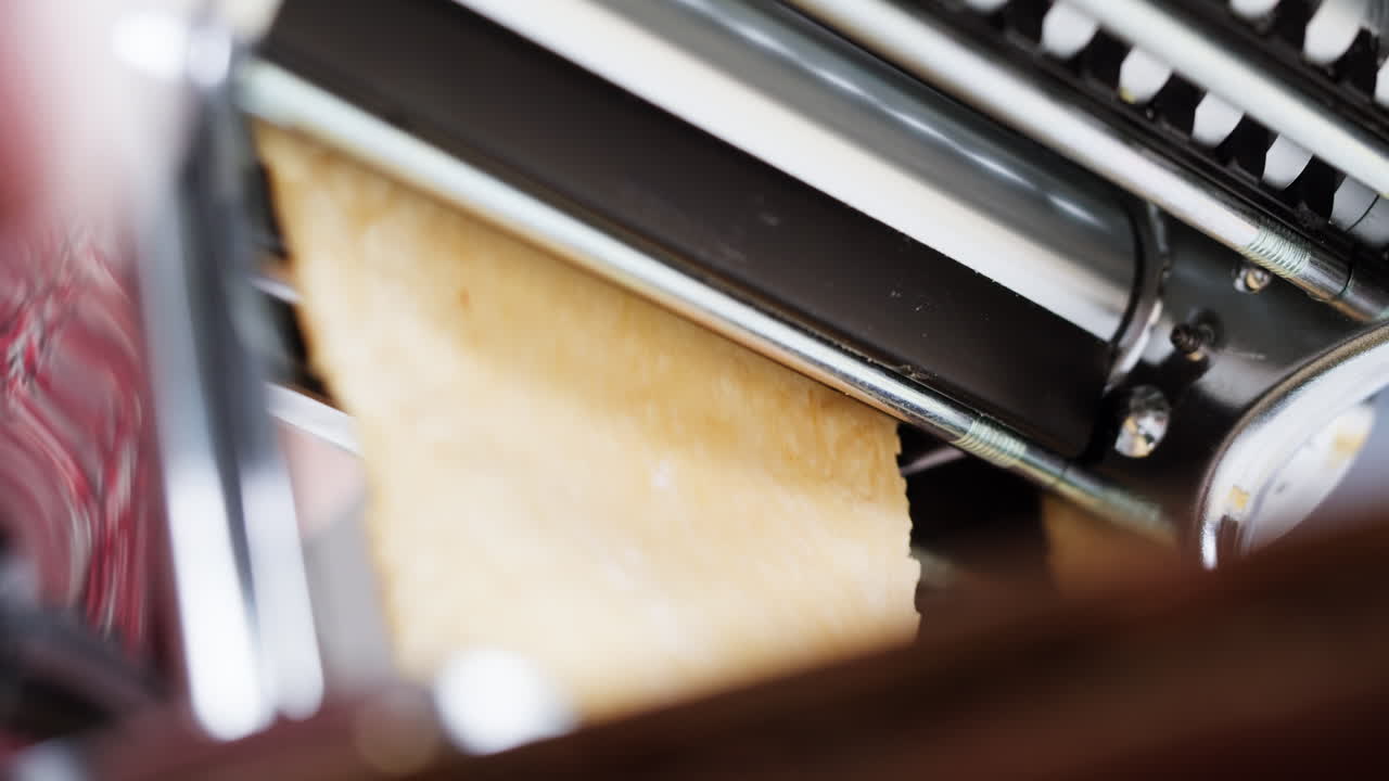 Close Up of Pasta Dough Being Flattened by a Machine