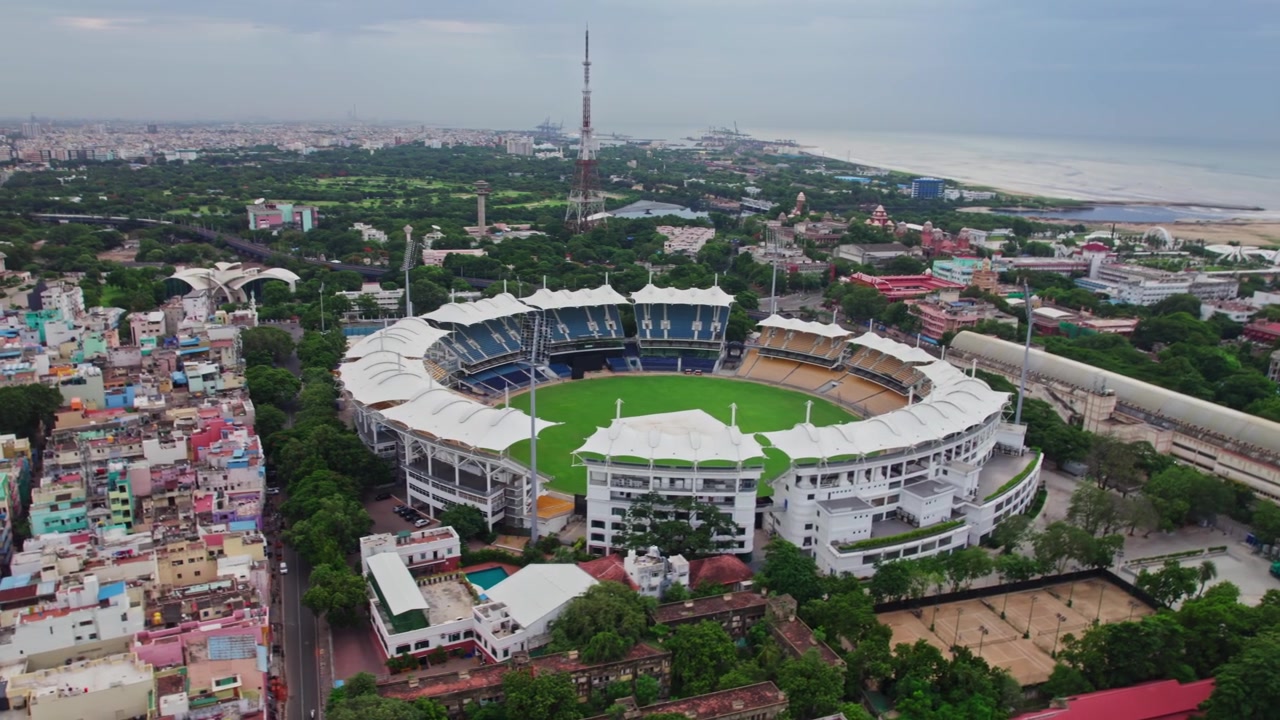 Luftfoto af Chepauk Stadion med Marina Beach i baggrunden i Chennai, Tamil Nadu, droneoptagelse i semi-orbit om dagen.