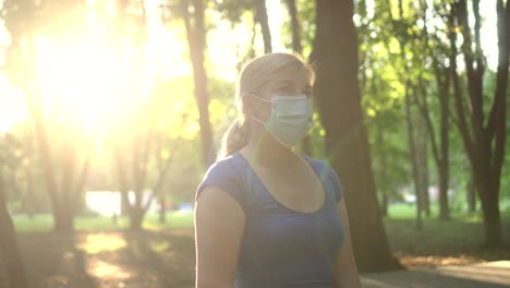 una mujer lleva una máscara médica en un parque 01