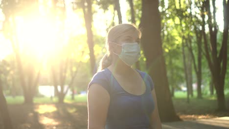 a woman wears a medical mask in a park 01