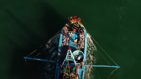 a vertical shot of a fishing boat sailing through the sea waters in vietnam