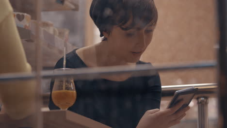 Female-friends-in-cafe-talking-when-using-cellphones