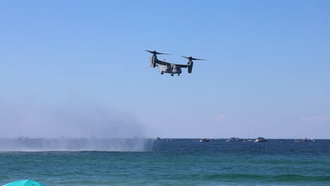 helicóptero volando sobre el océano cerca de un barco naval