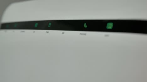 actualizado: router wi-fi, red doméstica, tecnología inalámbrica. un router de internet wi-fi con tres computadoras conectadas a una red local parpadea luces en una habitación oscura.