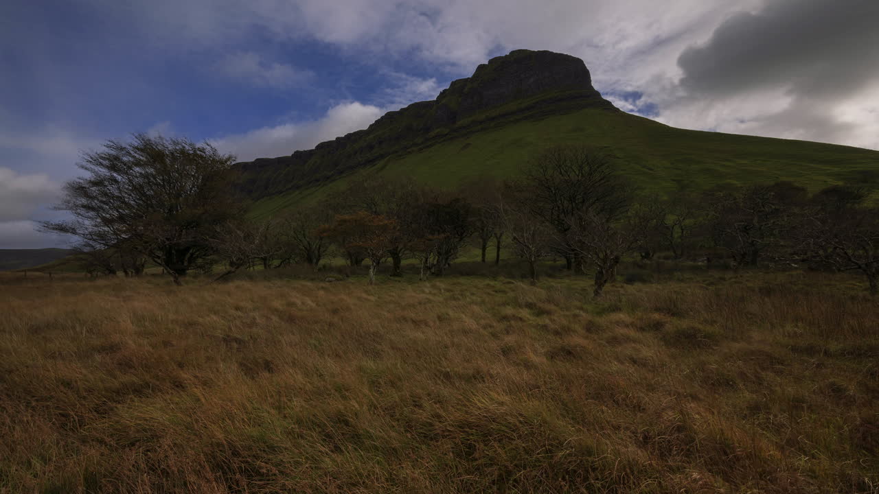 lapso de tiempo del paisaje agrícola rural con campo de hierba y árboles y nubes en movimiento en la montaña benbulben en el condado de sligo en irlanda