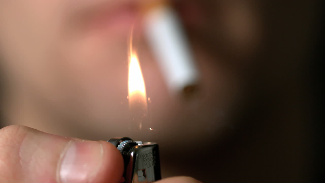 hombre a punto de encender un cigarrillo con un encendedor