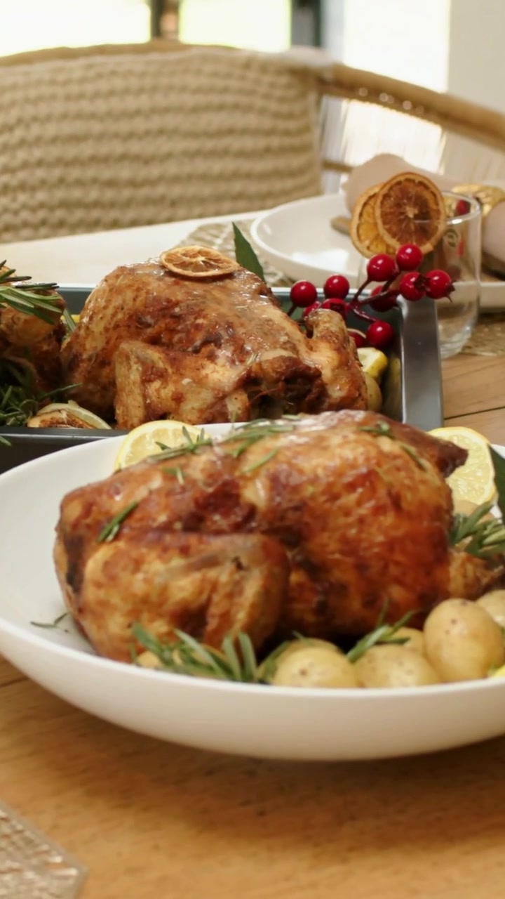 Video verticale: Panoramica dal mais che mostra pollo arrosto, pane e agrumi su un tavolo da pranzo per un banchetto.
