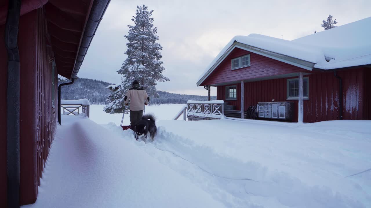 hombre limpiando el patio trasero en nieve profunda usando una pala de trineo en indre fosen, noruega - ancho