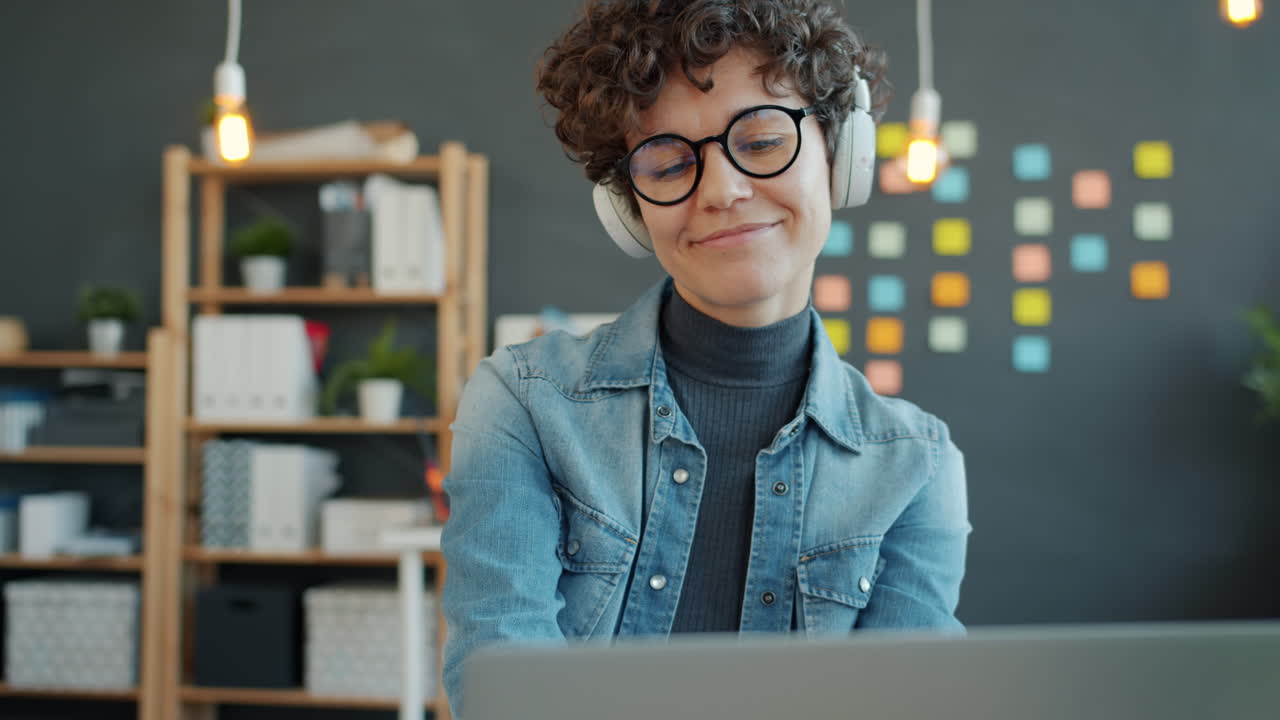 mujer trabajando en una computadora portátil con auriculares