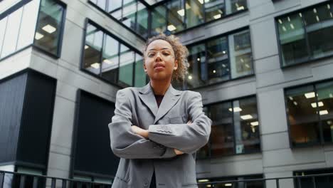 confident young woman in gray suit in front of modern building