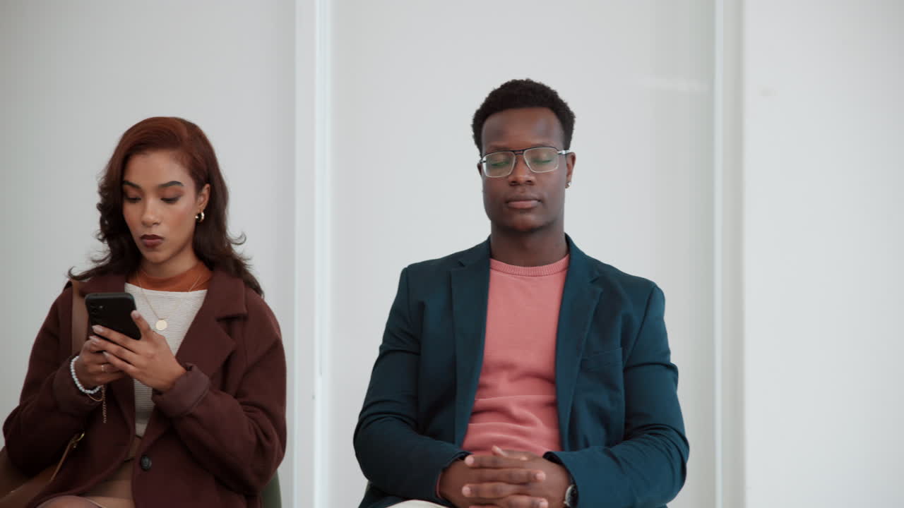 People in a waiting room looking at technology