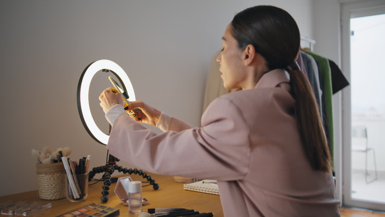 Blogger woman putting smartphone tripod at home close up. Influencer streaming