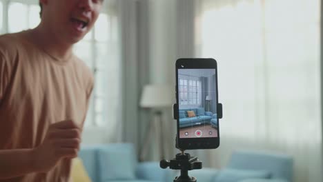 display smartphone of asian man dancing while shooting video content for social networks