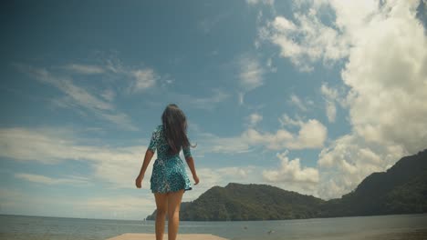 Pelicans-landing-in-the-ocean-while-a-girl-walks-down-the-jetty