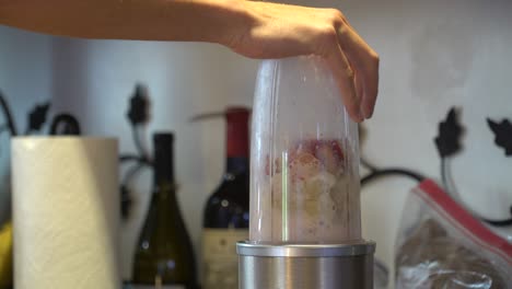 person blending fruit smoothie in a blender