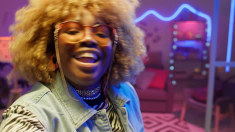 trendy african american blogger posing for camera and dancing