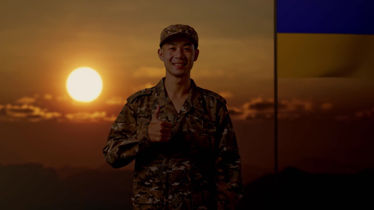 해가 지는 동안 엄지손가락을 들고 위장 유니폼을 입은 군인
