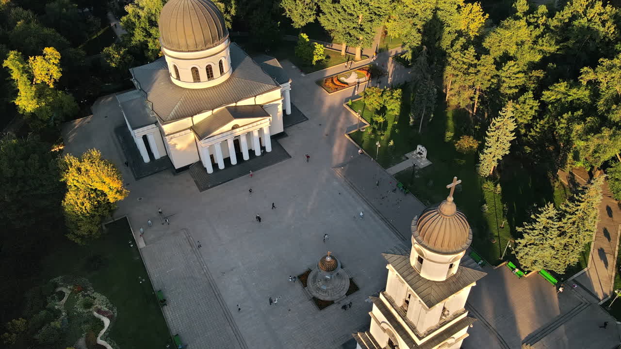 Aerial drone view of Chisinau downtown at sunset. View of central park, Cathedral, bell tower, a lot of greenery, walking people. Moldova