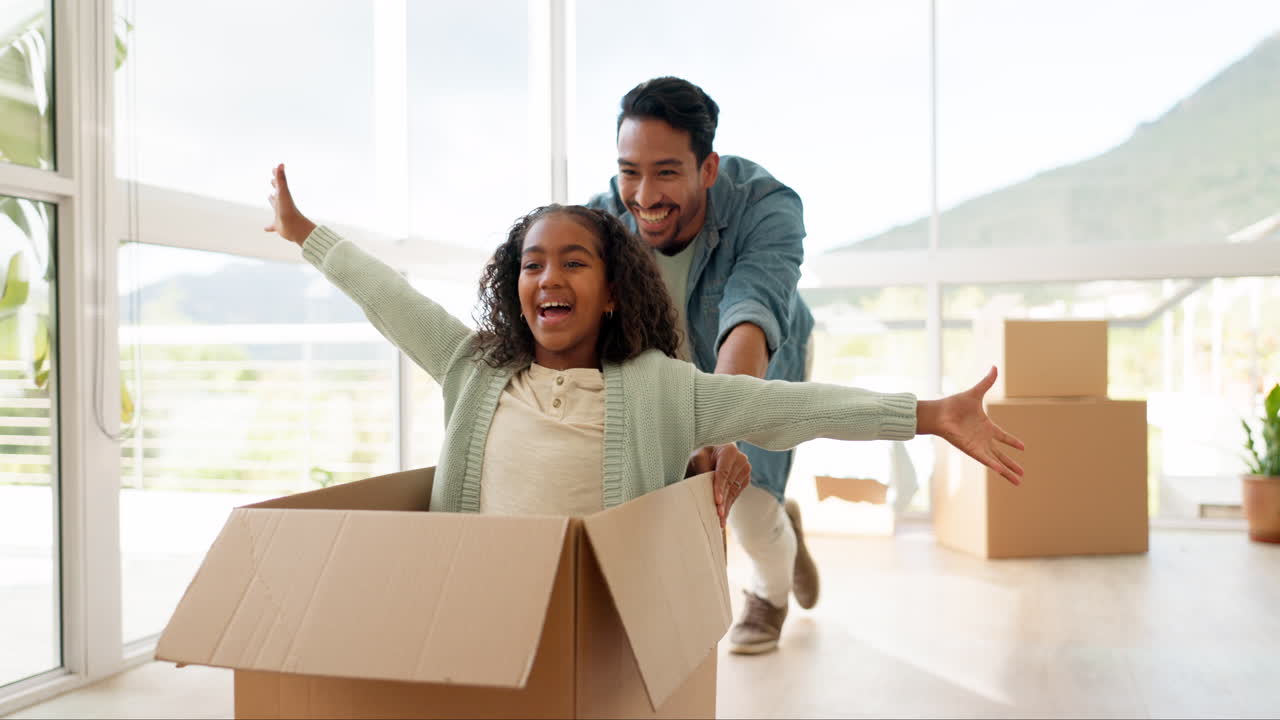 nuevo hogar, padre e hija jugando con la caja