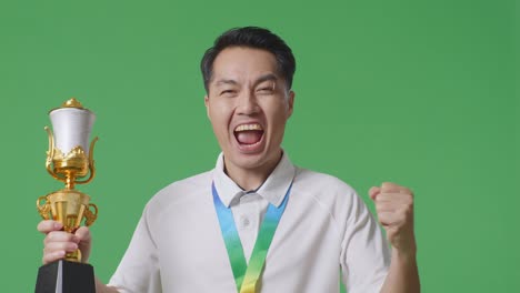 man celebrating victory with a trophy