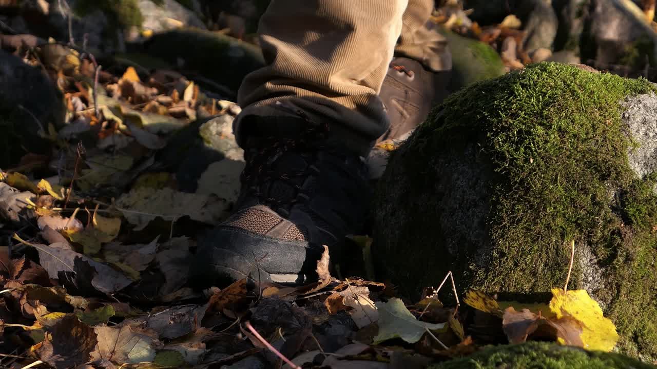 hombre caminando en el bosque de otoño, hojas caídas en el suelo, de cerca