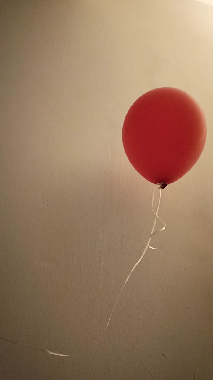 Ripresa verticale che mostra un palloncino rosso con un filo bianco che galleggia all'interno di una casa a Città del Messico